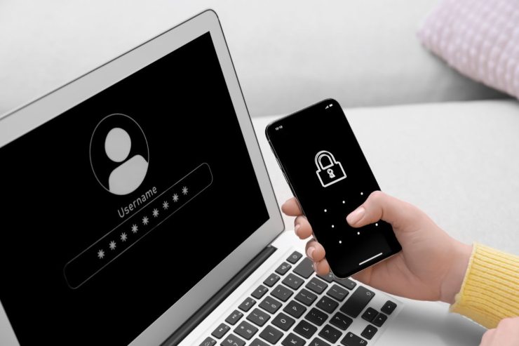 persona che usa laptop e smartphone con blocco schermo