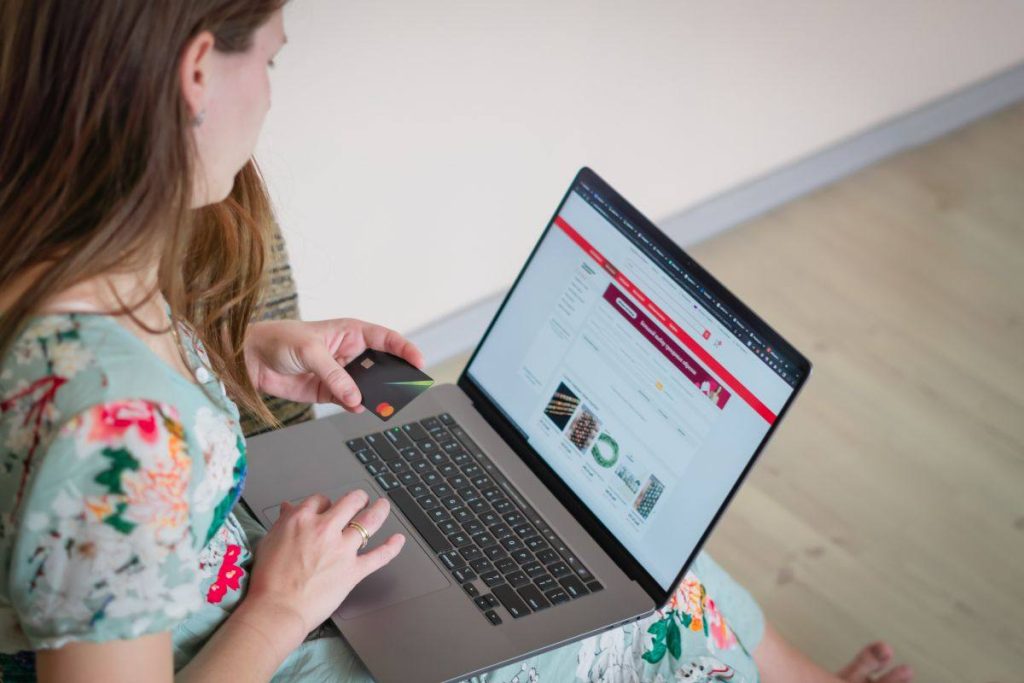 persona al pc con carta di credito in mano
