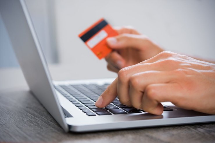 laptop e mano di una persona con carta di credito